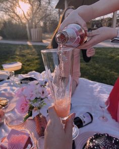 a person pouring champagne into a glass on top of a table