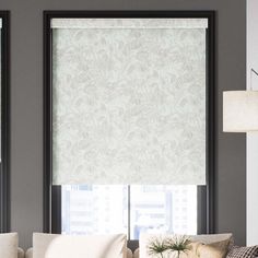 a living room with two couches and a window covered in roman blind coverings