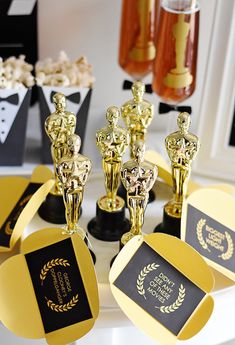 several awards are sitting on a table with popcorn in the background and other items around them