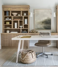 a desk with a chair, bookshelf and painting on the wall behind it