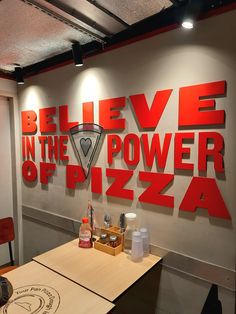 there is a pizza sign on the wall in this restaurant that says believe in the power of pizza