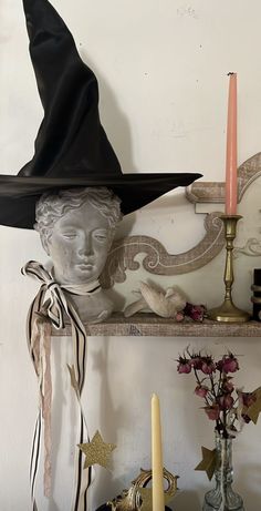 there is a shelf with candles and decorations on it, including a witch's hat