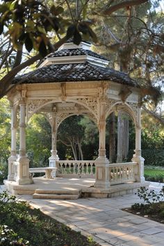 a white gazebo sitting in the middle of a park