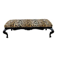 a leopard print bench with black legs and an upholstered seat cover on it