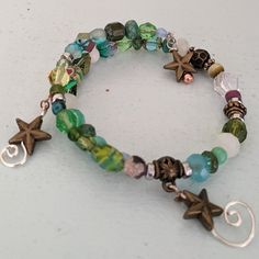 This Is A Fun Bracelet With Various Glass Beads In Shades Of Blue And Green With Handmade Coil Spirals Hanging From The Ends. Blue Bracelets Aesthetic, Unique Bead Bracelets, Grudge Bracelets, Beaded Crystal Bracelets, Grunge Bracelet Ideas, Bracelet Ideas Grunge, Bead Bracelet Inspiration, Eclectic Bracelets, Bracelet Patterns Beads