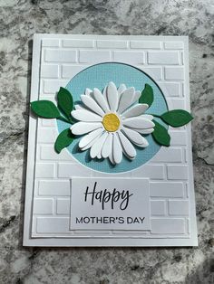 a mother's day card with a white flower on the front and green leaves on the back