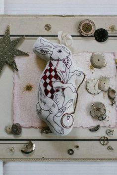 a stuffed animal sitting on top of a piece of cloth next to buttons and other items