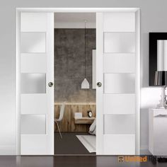 an open door leading to a bedroom with white furniture