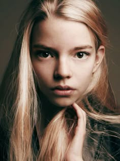 a woman with long blonde hair posing for the camera