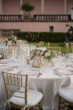 the tables are set with white linens and gold chairs