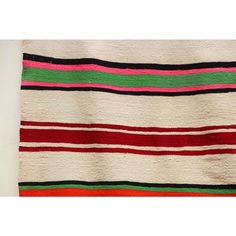 a multicolored striped rug is hanging on the wall