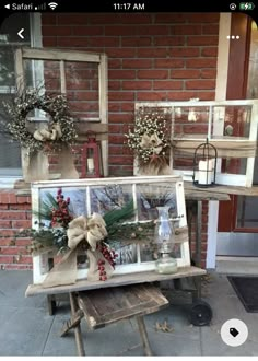 an old window is decorated with wreaths and other decorations for the front door to be displayed