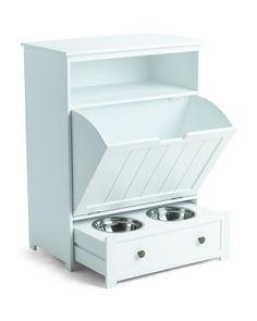 an open white cabinet with two bowls in the bottom and one drawer on the side