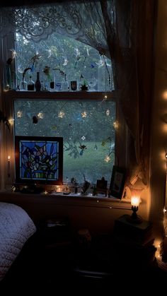 a bedroom window with fairy lights hanging from it's sides and candles on the windowsill