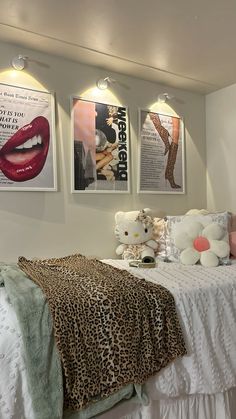 a bed room with a neatly made bed and pictures on the wall above it's headboard