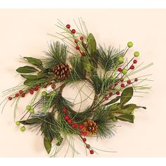 a wreath with pine cones, berries and green leaves is displayed on a white background