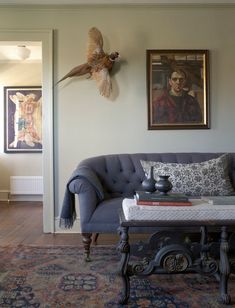 a living room filled with furniture and paintings on the wall