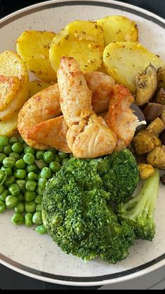 a white plate topped with shrimp, potatoes and broccoli covered in seasoning