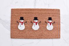 a door mat with three snowmen on it