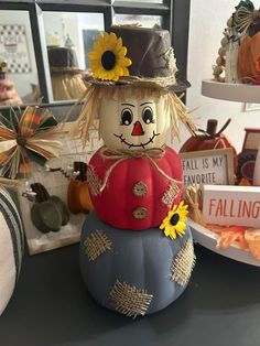 a scarecrow sitting on top of a pumpkin with sunflowers in its hair