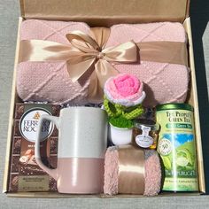 a pink gift box filled with coffee, tea, and other personal care items for someone's special occasion