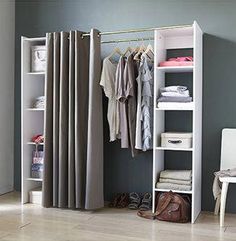 an open closet with clothes and shoes hanging on the rack, next to a chair