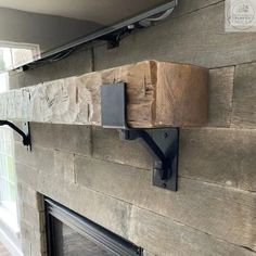 a fireplace with some wood on the mantle and a tv mounted above it's head