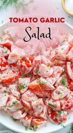 a white bowl filled with tomato salad on top of a table