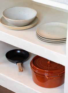 a shelf with plates and pans on it