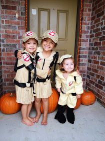 three children dressed up in costumes posing for a photo on the front porch with pumpkins