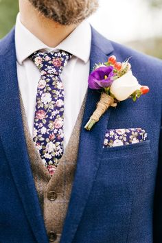 a man wearing a suit and tie with flowers on his lapel flower boutonniere