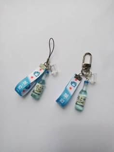 three toothbrushes are attached to two key chains with plastic bottles hanging from them