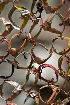 many pairs of glasses are hanging on a chain with metal rings attached to them,