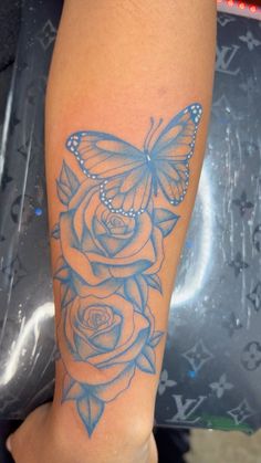 a butterfly and roses tattoo on the leg