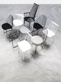 six chairs and one table are arranged in the shape of a circle on concrete flooring