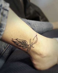 a woman's foot with an angel tattoo on it