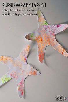 two starfishs made out of paper on a white surface with text bubblewrap starfish simple art activity for toddlers and preschoolers