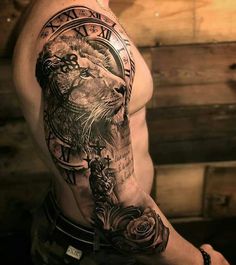 a man's arm with a lion tattoo on it and roses in the middle