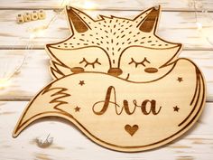 a wooden sign with an image of a sleeping fox and the word ava on it