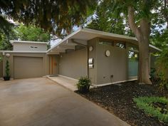 a house that is sitting in the middle of a tree lined driveway with lots of trees around it