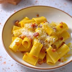 a white plate topped with pasta covered in cheese