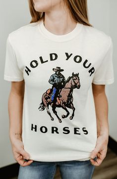 Channel your inner cowgirl with our "Hold Your Horses" Vintage Western Tee, designed for the free-spirited woman who loves a relaxed, lived-in look. Crafted from ultra-soft, ring-spun cotton, this garment-dyed tee is pre-shrunk to ensure it keeps its shape wash after wash. The vibrant Western-inspired design features a rugged cowboy and trusty steed, perfect for adding a touch of Southwestern charm to your wardrobe. With a classic relaxed fit and durable construction, this tee offers comfort and Rugged Cowboy, Hold Your Horses, Grafic Tees, Grunge Tee, Cute Country, Perfect Live, Free Spirited Woman, Western Tee, Cowgirl Shirts