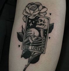 a black and white photo of a tattoo with a rose on the arm that says he loves