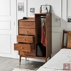 a wooden cabinet with three drawers next to a bed