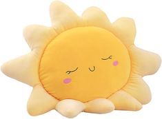 a yellow sun pillow sitting on top of a white floor