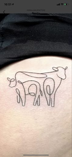 a cow tattoo on the back of a woman's lower thigh, with two cows in it