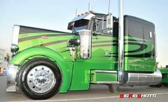 a green semi truck parked in a parking lot