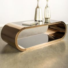 a modern coffee table with two silver vases on it's sides and a magazine rack in the middle