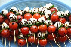 skewered tomatoes and mozzarella on toothpicks in a blue bowl