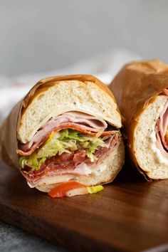 a cut in half sandwich sitting on top of a wooden cutting board